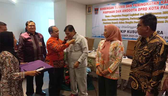 Ikuti Bimtek, Pimpinan dan Anggota DPRD Padang Diasah Tingkatkan Fungsi Legislasi dan Pengawasan Anggaran 3 Ketua DPRD Kota Padang, Muharlion memasangkan tanda peserta Bimtek